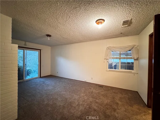 a view of an empty room with wooden floor and windows