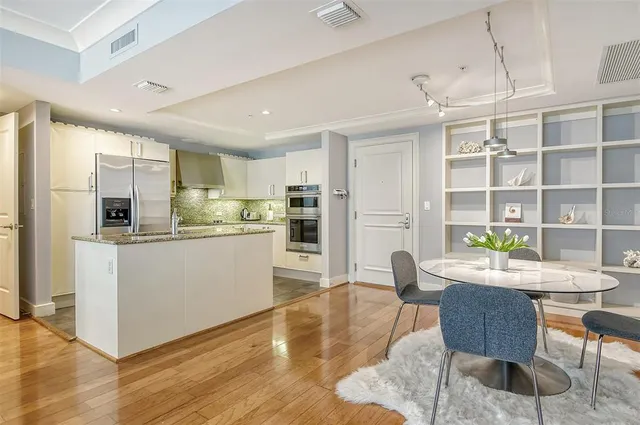 a kitchen with stainless steel appliances granite countertop a sink a stove and a refrigerator