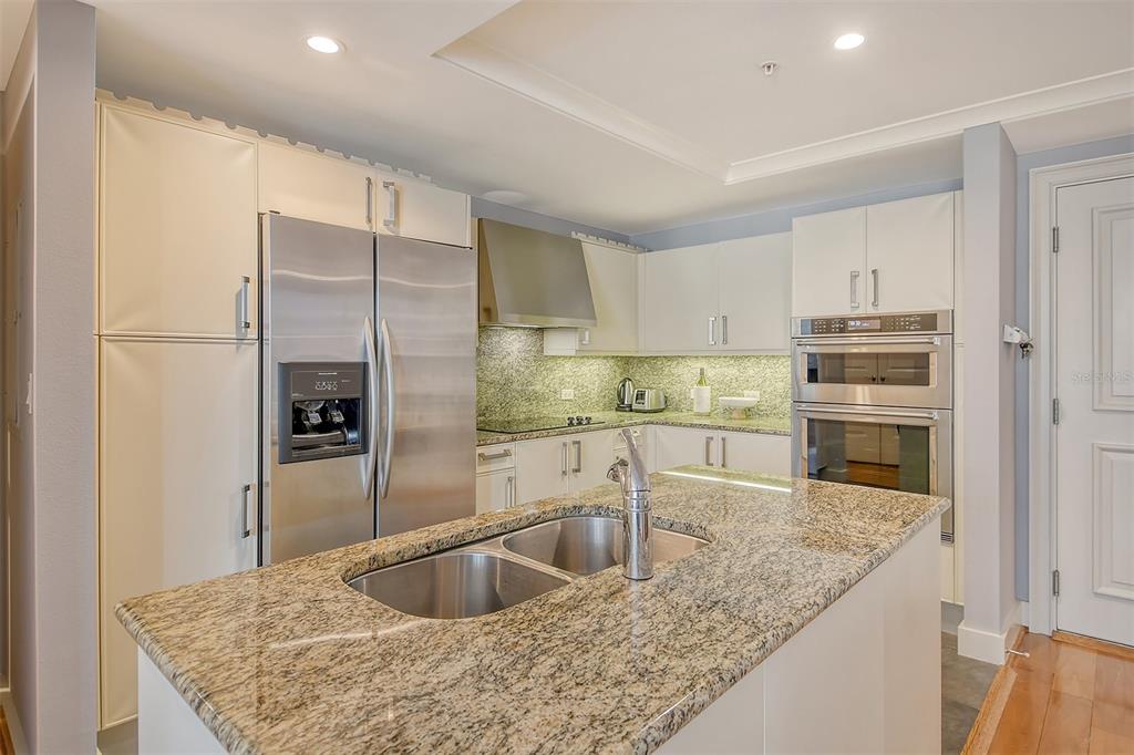 1350 Main Street, Unit 903 Sarasota, FL 34236 - Photo 16 of 71 a kitchen with stainless steel appliances granite countertop a sink a stove and a refrigerator