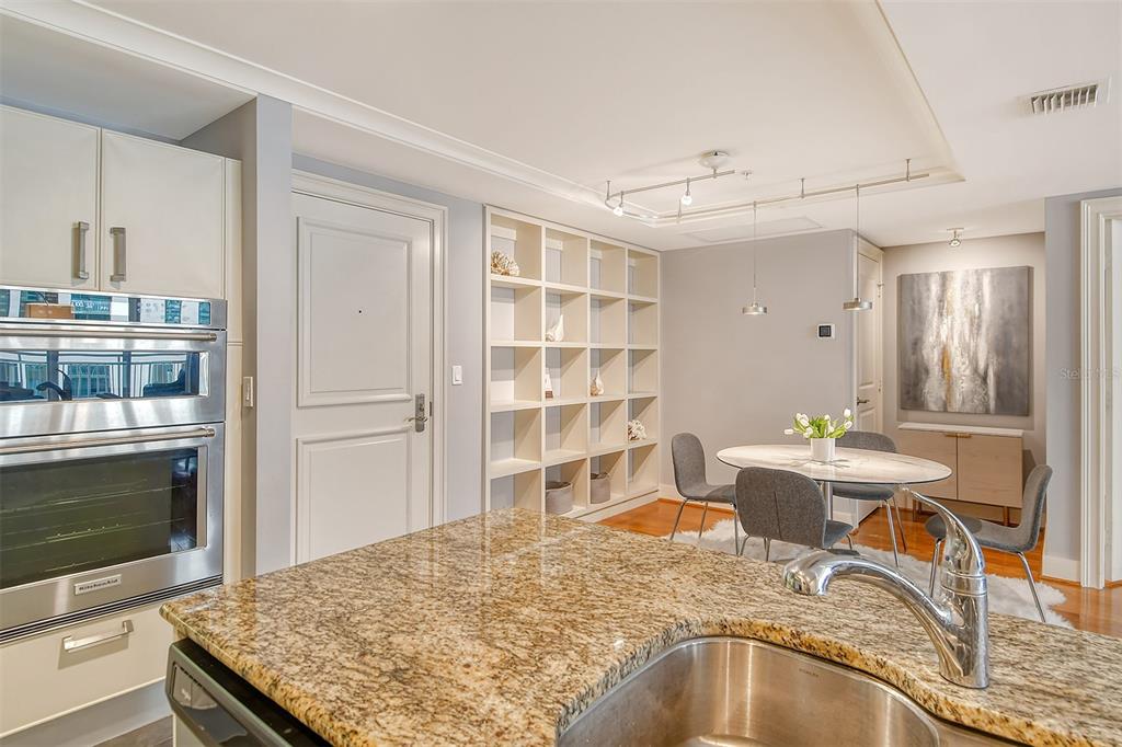1350 Main Street, Unit 903 Sarasota, FL 34236 - Photo 19 of 71 a living room with stainless steel appliances granite countertop a stove top oven a sink dishwasher a dining table and chair with wooden floor