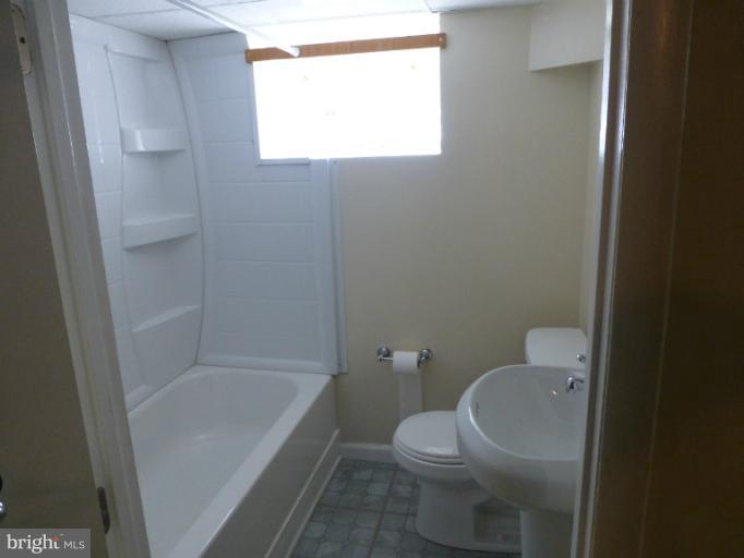 11925 Andrew Street Silver Spring, MD 20902 - Photo 14 of 23 a bathroom with a granite countertop toilet and a bathtub