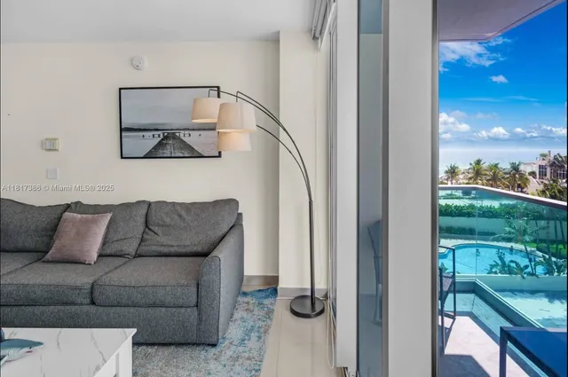 a living room with furniture and a floor to ceiling window