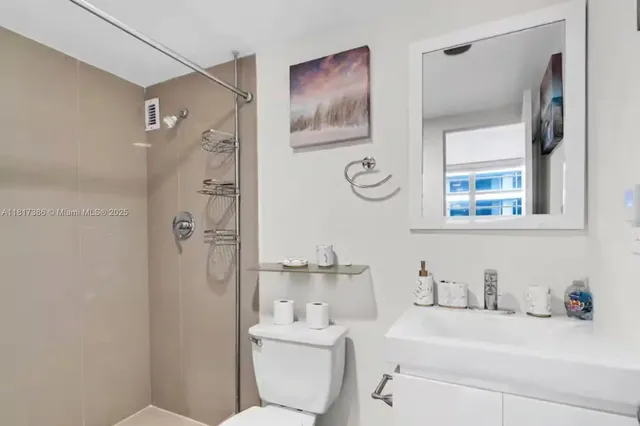a bathroom with a sink a toilet and shower