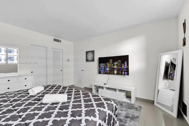 a bedroom with a bed and a flat screen tv