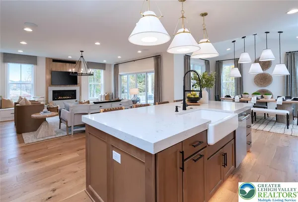 a dining room with wooden floor kitchen a chandelier a wooden table and chairs