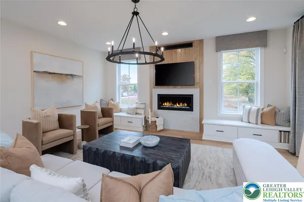a living room with furniture a flat screen tv and a fireplace