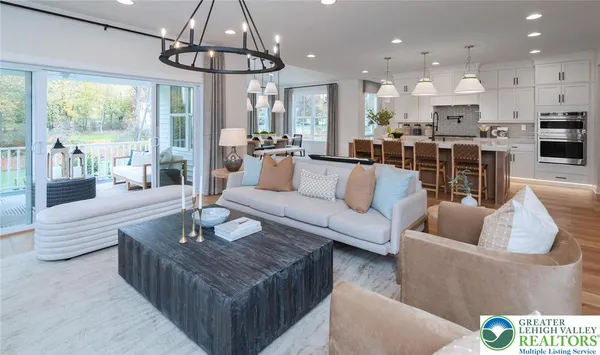 a living room with furniture kitchen and a chandelier