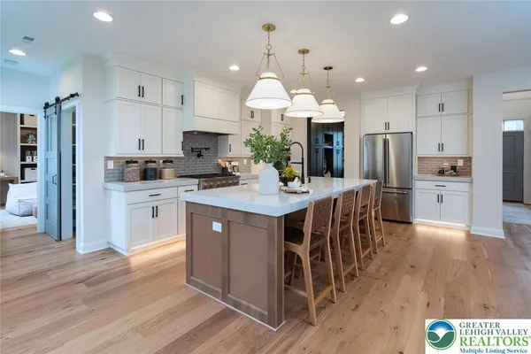a kitchen with stainless steel appliances granite countertop a sink a stove and a wooden floors