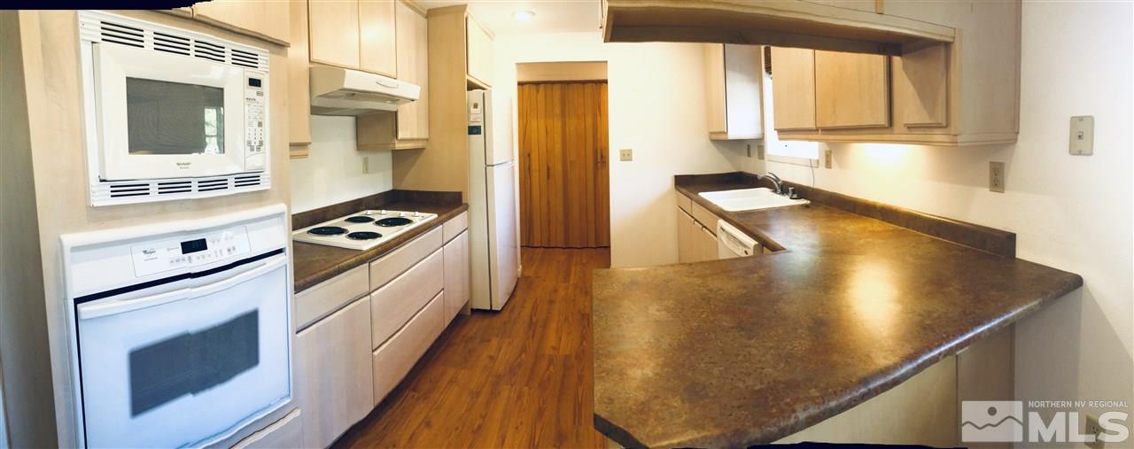 13870 Chamy Drive Reno, NV 89521 - Photo 5 of 21 a kitchen with stainless steel appliances granite countertop a stove a sink and a refrigerator