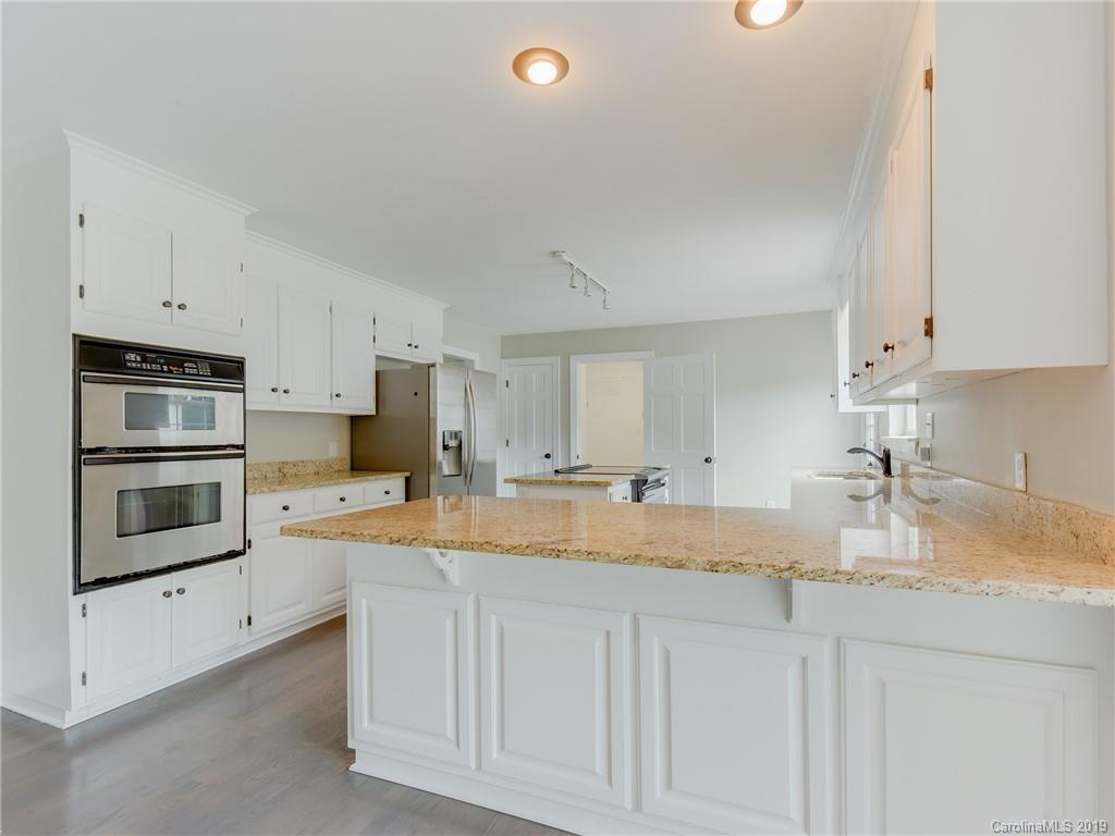 4805 Wolf Pond Road Monroe, NC 28112 - Photo 22 of 36 a kitchen with stainless steel appliances granite countertop a sink a stove and cabinets