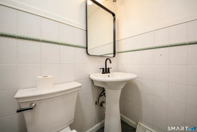 a bathroom with a sink a toilet and a mirror