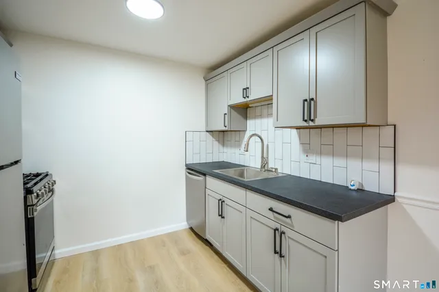 a kitchen with granite countertop a sink and cabinets