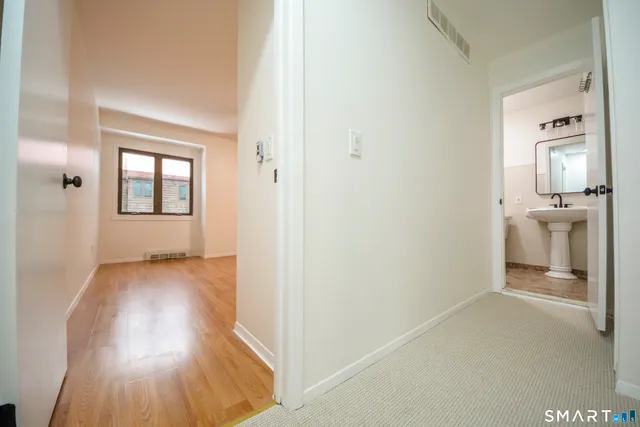 an empty room with wooden floor and mirror