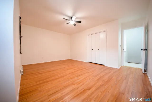 a view of empty room with wooden floor