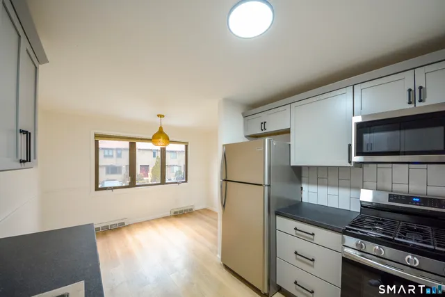 a kitchen with stainless steel appliances a refrigerator stove and microwave