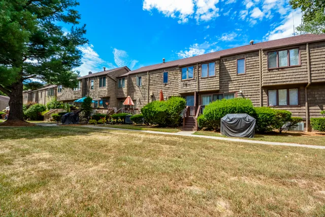 a front view of a house with a yard and outdoor seating