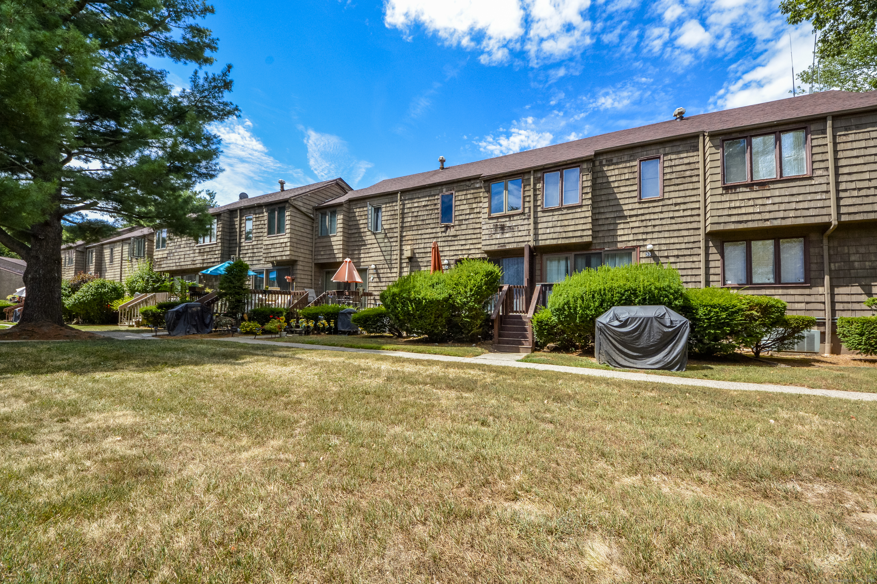 32 Towne House Road, Unit 32 Hamden, CT 06514 - Photo 24 of 35 a front view of a house with a yard and outdoor seating