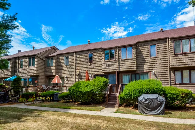 a front view of a house with a yard and potted plants