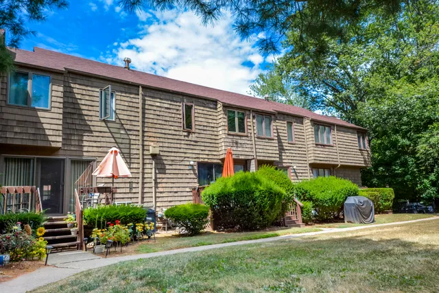 a front view of a house with a yard and potted plants