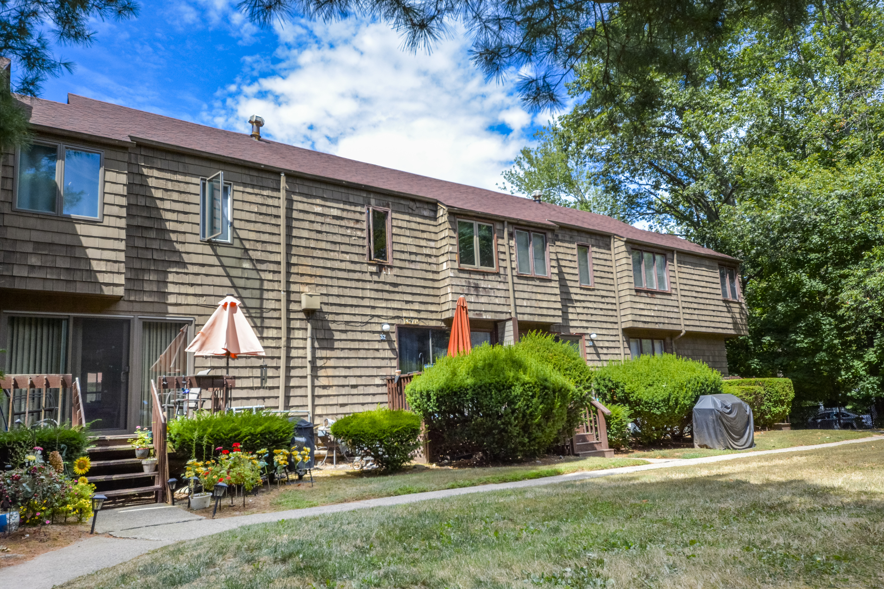 32 Towne House Road, Unit 32 Hamden, CT 06514 - Photo 31 of 35 a front view of a house with a yard and potted plants