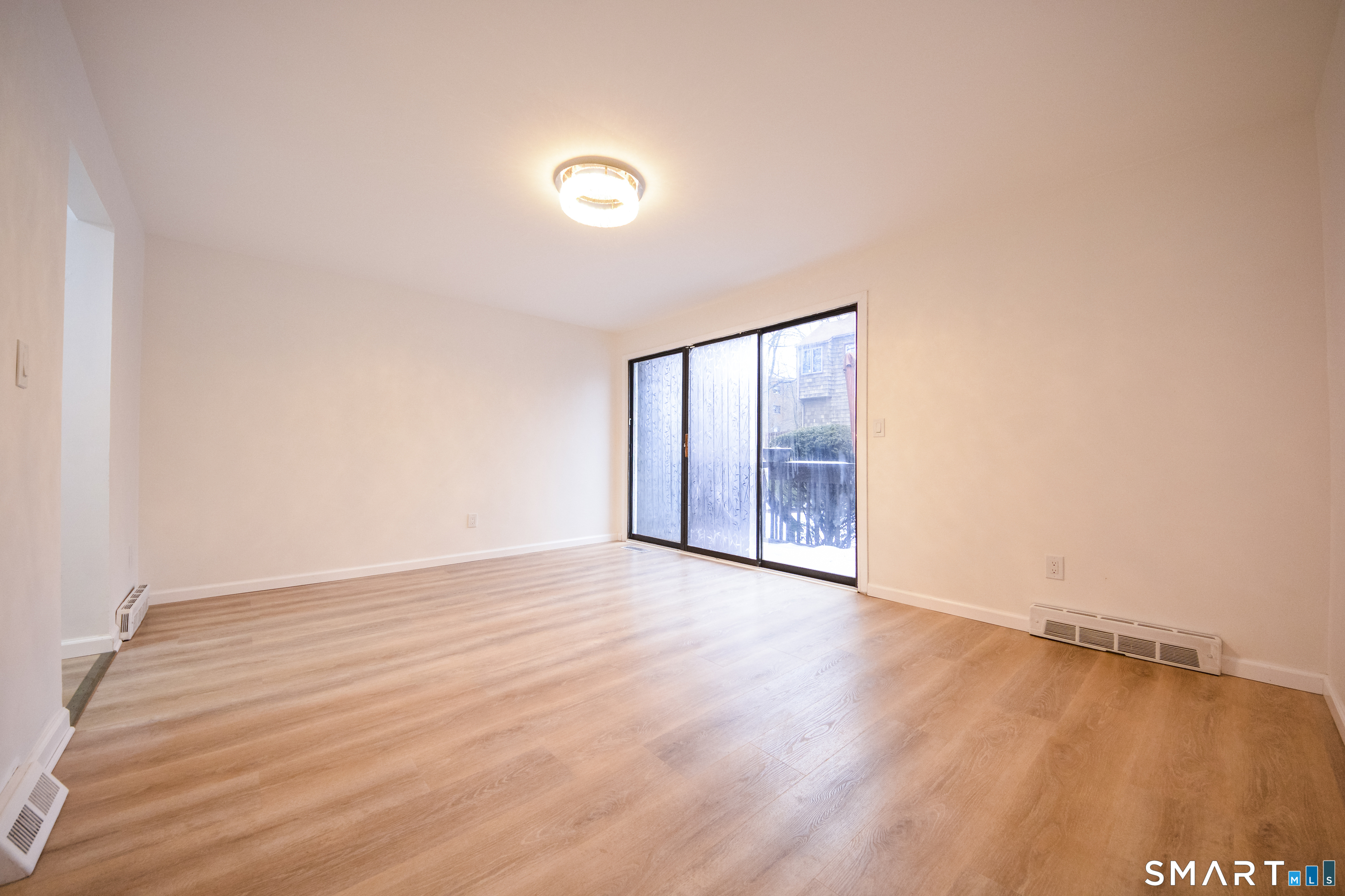 32 Towne House Road, Unit 32 Hamden, CT 06514 - Photo 7 of 35 an empty room with wooden floor and windows