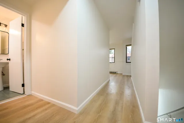a view of a hallway with wooden floor