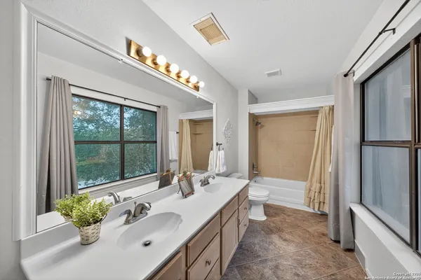 a spacious bathroom with a double vanity sink a mirror and a shower