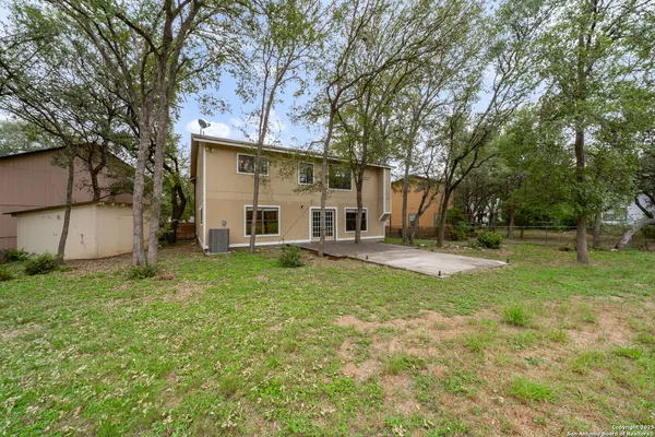 a view of a house with backyard and trees