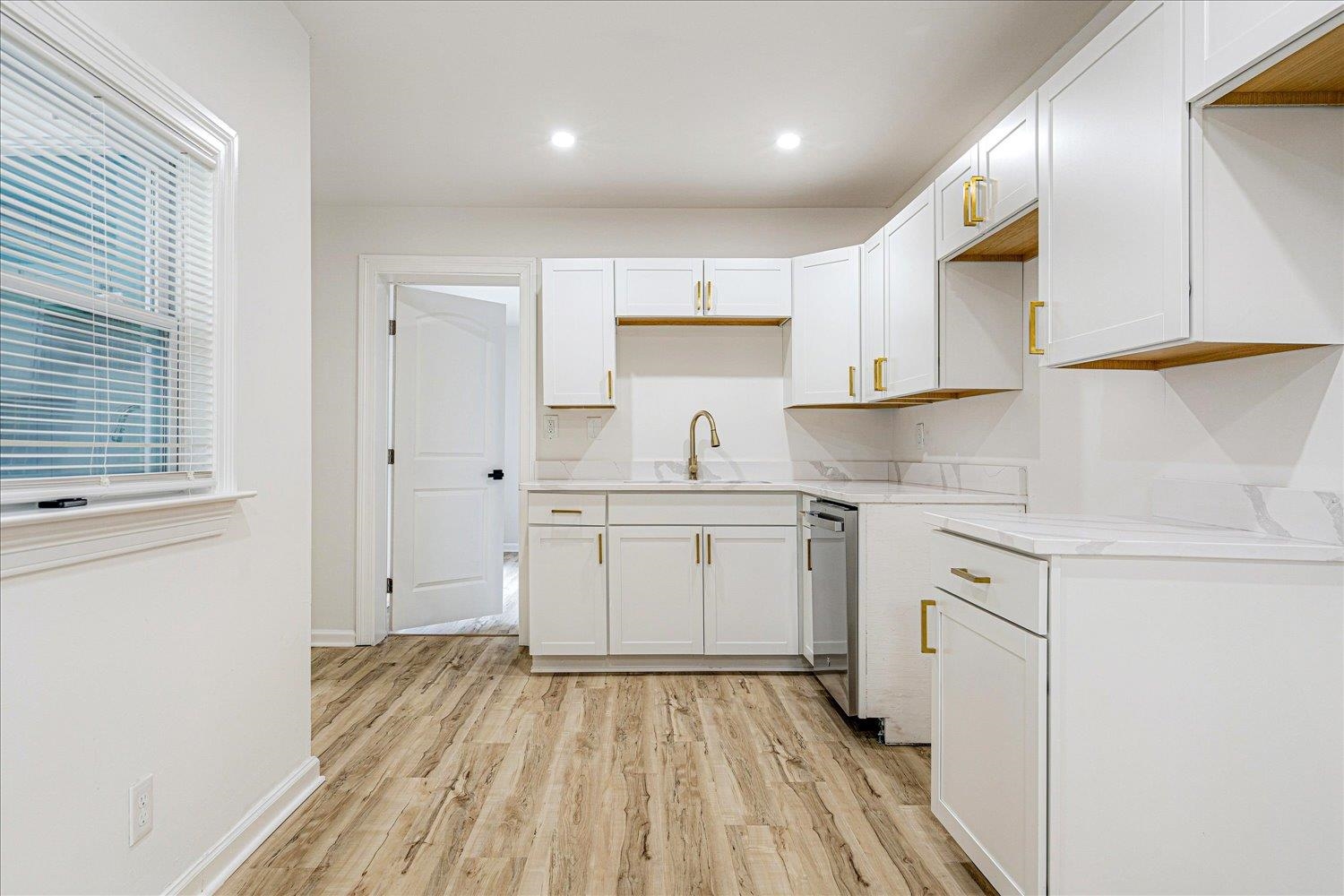 4016 Leech Road Memphis, TN 38109 - Photo 12 of 21 Kitchen featuring white cabinets, light wood finished floors, recessed lighting, stainless steel dishwasher, and light stone countertops