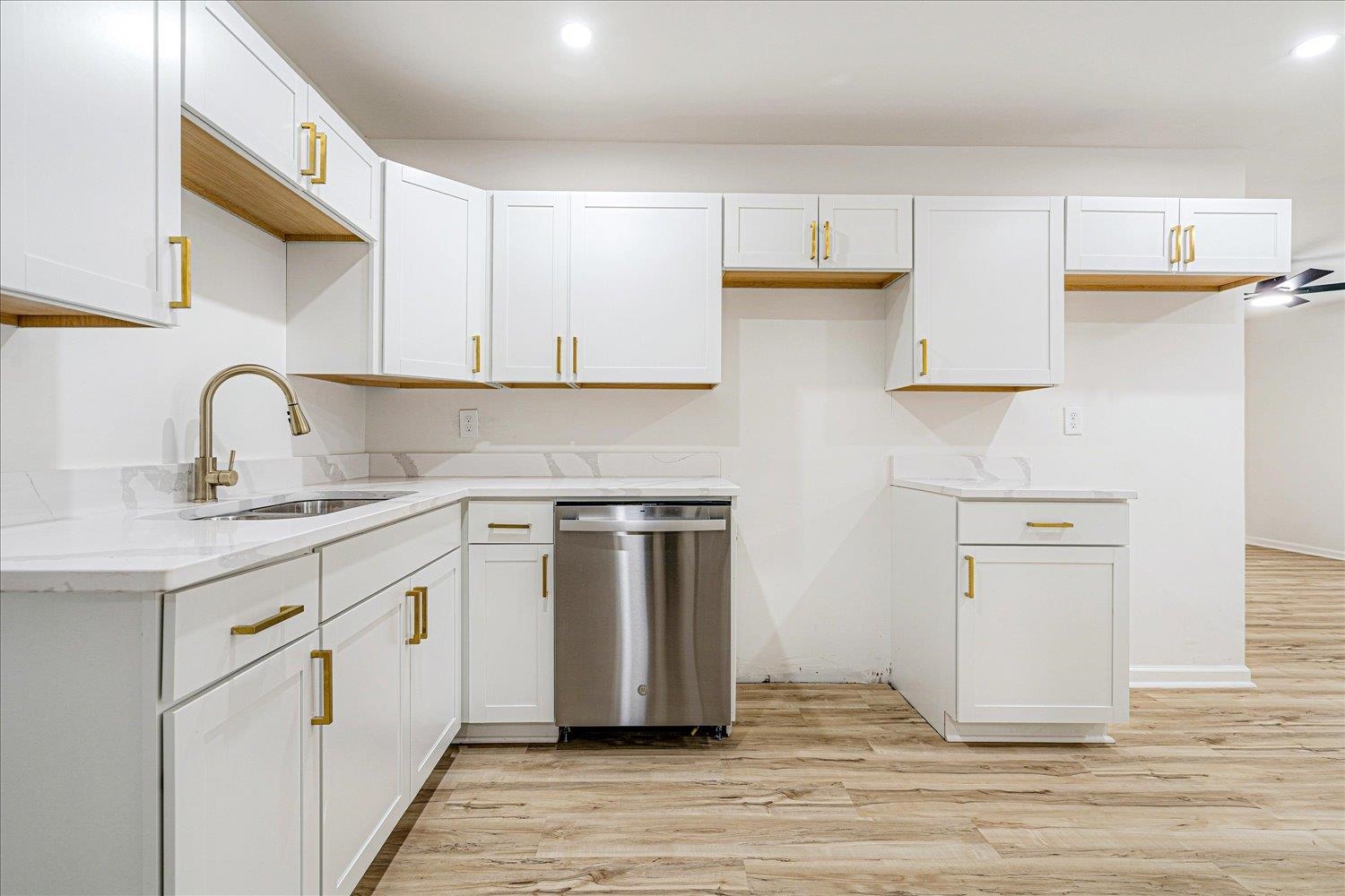4016 Leech Road Memphis, TN 38109 - Photo 13 of 21 Kitchen featuring stainless steel dishwasher, recessed lighting, light wood-style flooring, white cabinetry, and light stone counters