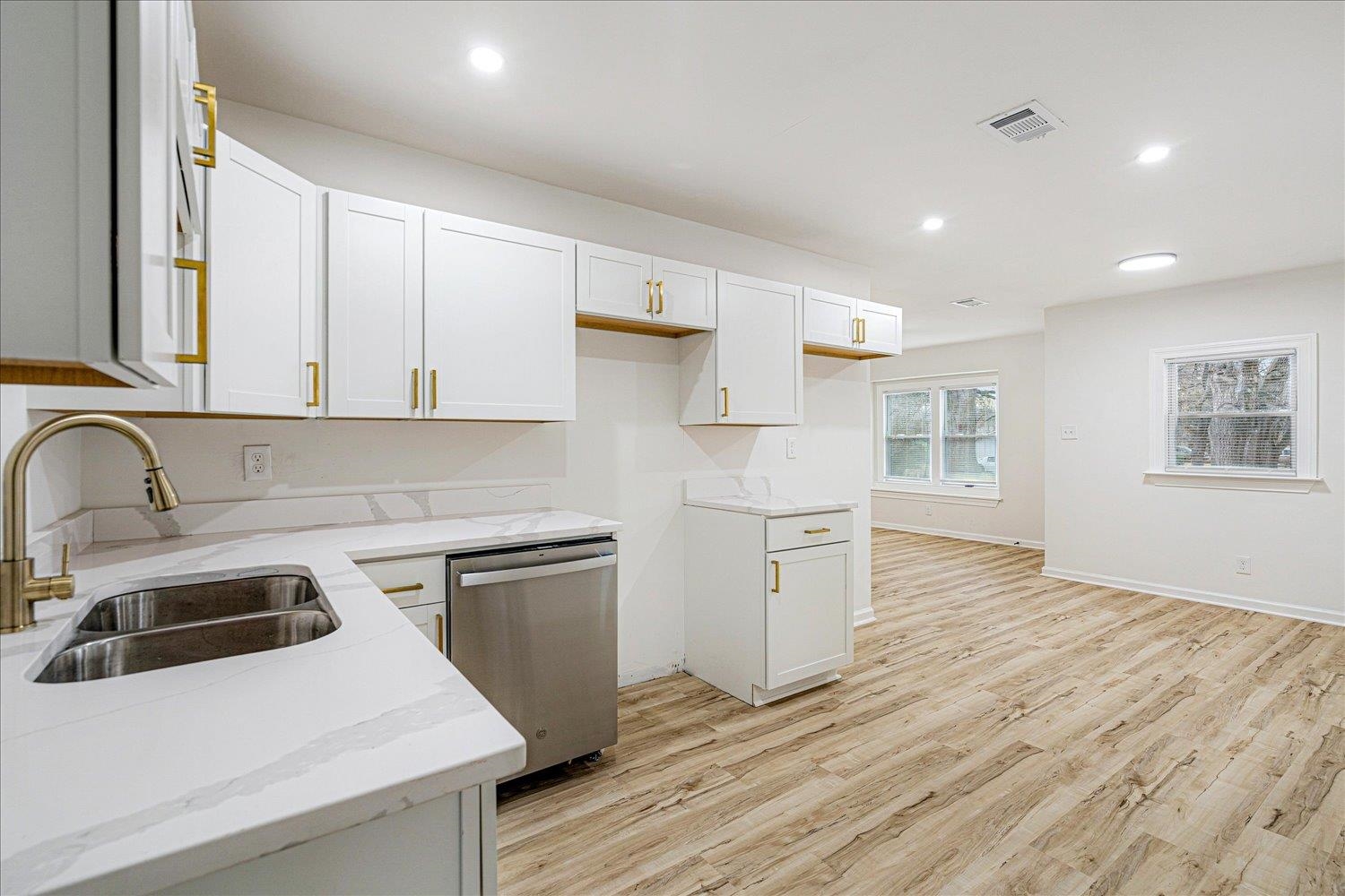 4016 Leech Road Memphis, TN 38109 - Photo 14 of 21 Kitchen featuring recessed lighting, dishwasher, light wood-style floors, white cabinetry, and light stone countertops