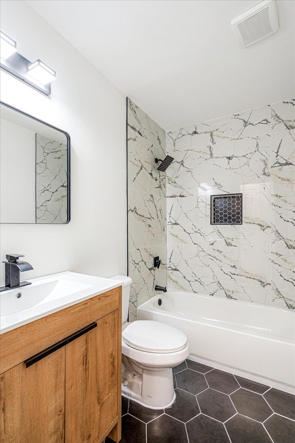 4016 Leech Road Memphis, TN 38109 - Photo 17 of 21 Bathroom with vanity, tub / shower combination, and dark tile patterned floors