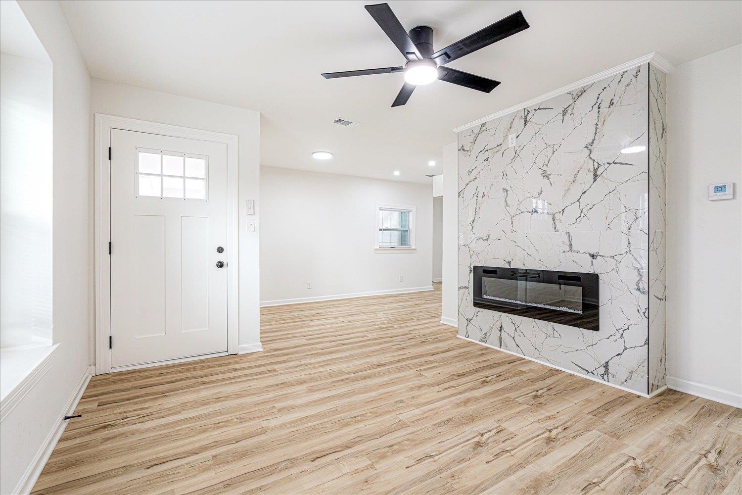 4016 Leech Road Memphis, TN 38109 - Photo 8 of 21 Unfurnished living room with a fireplace, light wood-type flooring, ceiling fan, and recessed lighting