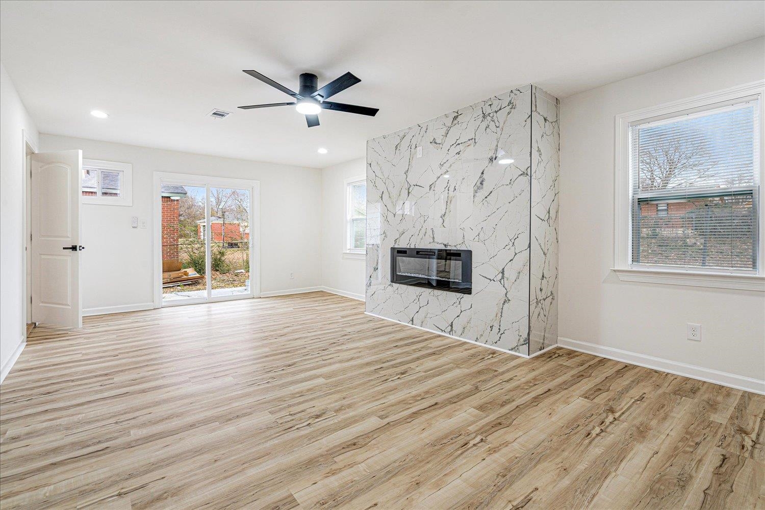 4016 Leech Road Memphis, TN 38109 - Photo 9 of 21 Unfurnished living room with a high end fireplace, light wood-style floors, a ceiling fan, and recessed lighting