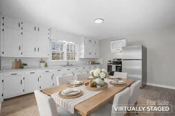 a kitchen with stainless steel appliances granite countertop a stove a sink and white cabinets