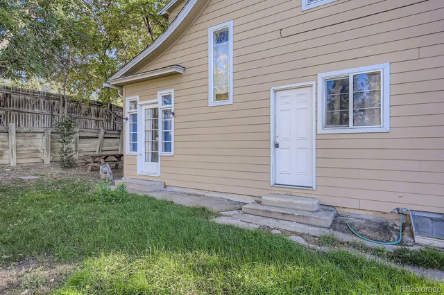 a view of house with backyard and a garden