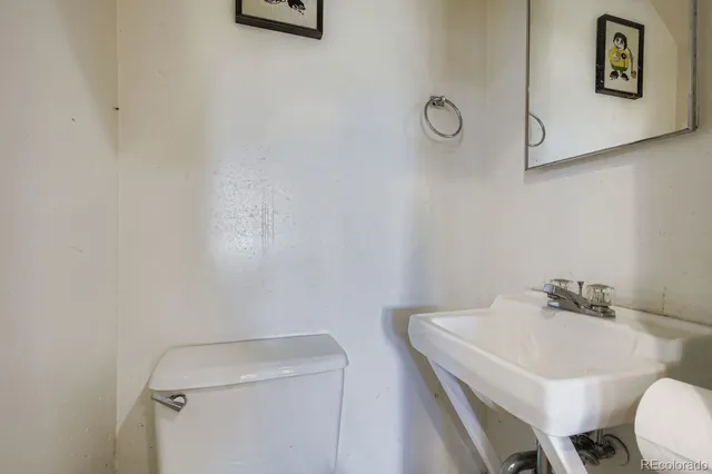 a bathroom with a toilet a sink and mirror