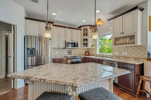 a kitchen with stainless steel appliances granite countertop a sink refrigerator and microwave