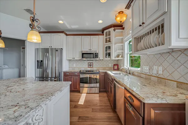 a kitchen with kitchen island granite countertop a sink stove and refrigerator