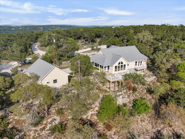 an aerial view of house with yard and mountain view in back