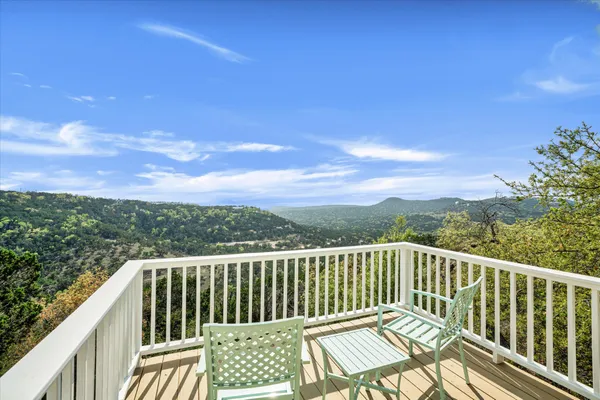 a view of a balcony with wooden floor and fence