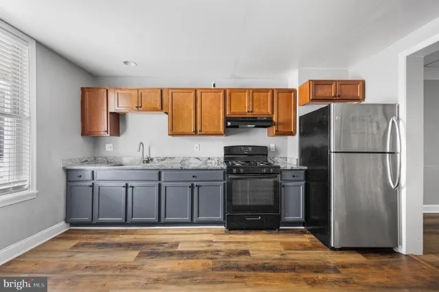 a kitchen with granite countertop a refrigerator stove and sink