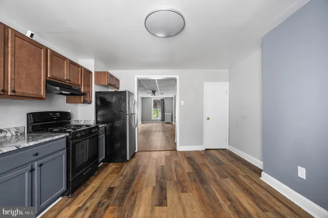 a kitchen with wooden floors and stainless steel appliances