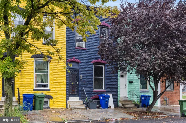 a view of a brick house with a large tree