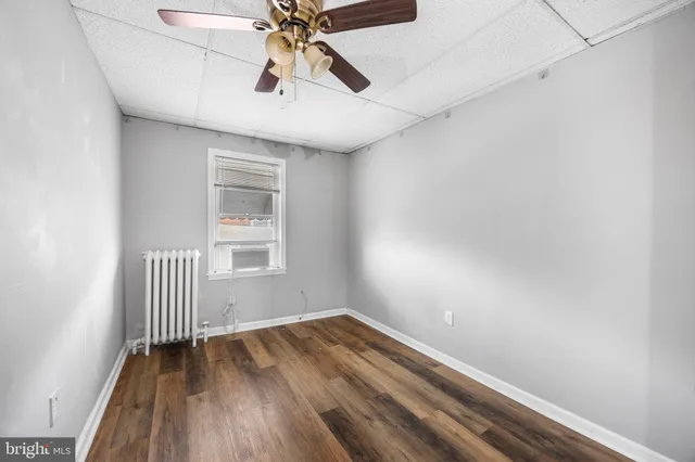 an empty room with a window and wooden floor