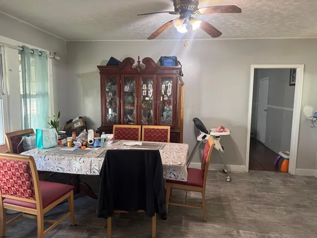 a view of a dining room with furniture and a chandelier fan