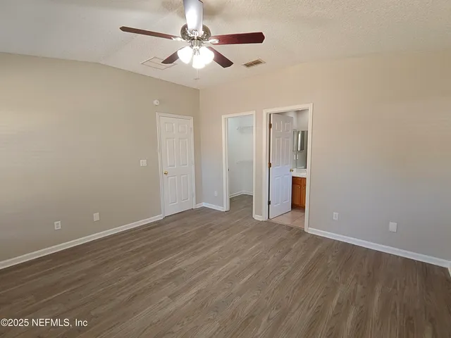 a view of a backyard with wooden fence and a large tree