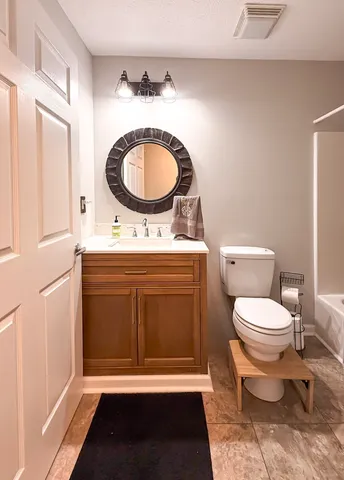 a bathroom with a toilet a sink and a mirror
