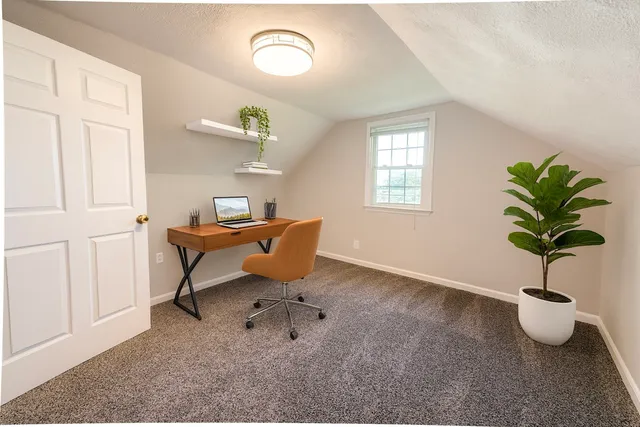 a work room with furniture and a potted plant