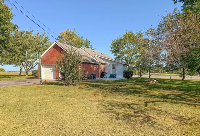 a front view of house with yard and trees